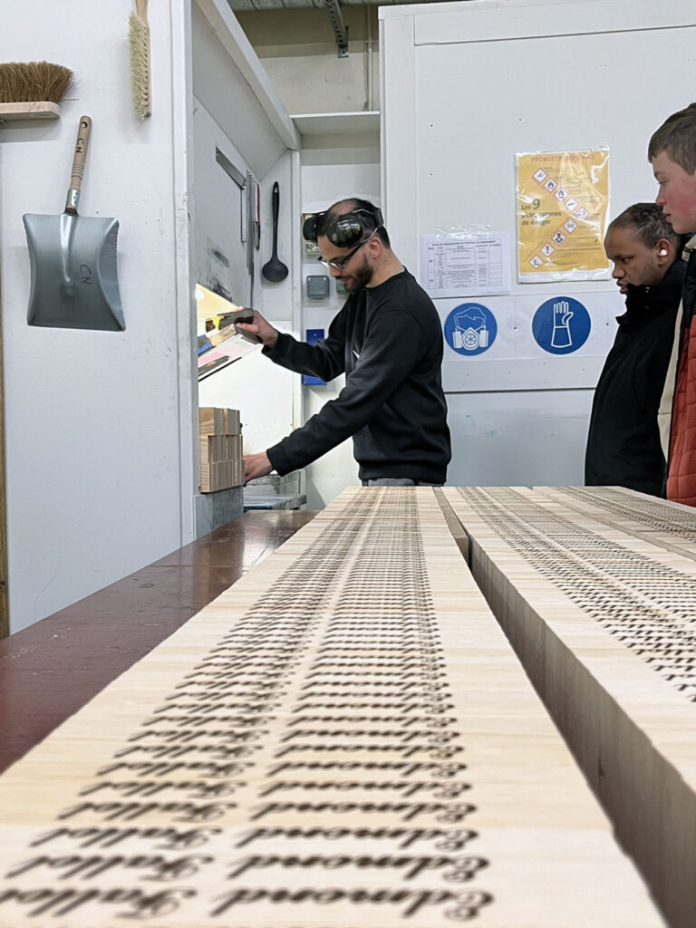 Salarié de l’atelier menuiserie de PROMUT effectuant une démonstration de sérigraphie pour un grand producteur de moutarde de Dijon.