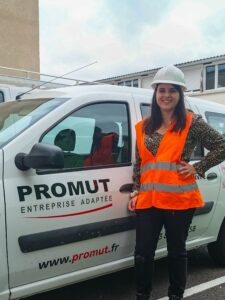 Mathilde DEWALLE en gilet de sécurité orange devant une voiture PROMUT Entreprise Adaptée